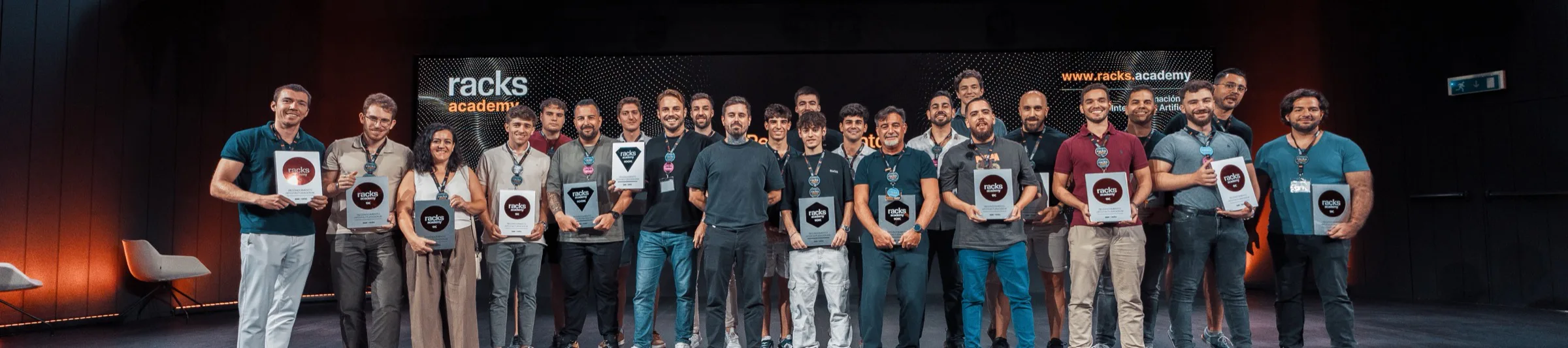 Los alumnos de Racks Academy con su diploma sobre el escenario, el día de la graduación